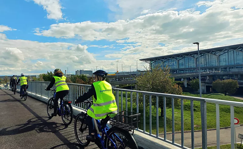 Photo de cyclistes devant l'aérogare de l'EuroAirport